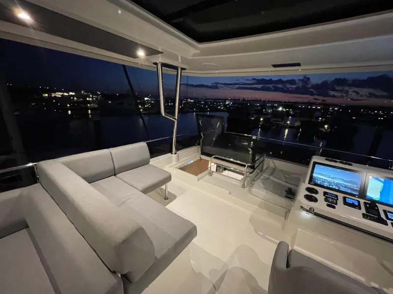 Slide: The Image of Luxurious interior of 2024 Beneteau Grand Trawler 62 at night, featuring modern seating and controls. - 31