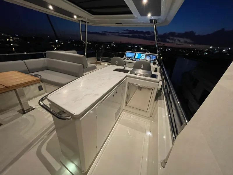 Slide: The Image of Luxurious 2024 Beneteau Grand Trawler 62 yacht interior at dusk, featuring elegant seating and helm. - 32