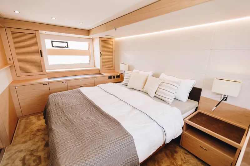 Slide: The Image of Luxurious bedroom interior of 2024 Beneteau Grand Trawler 62 yacht, featuring elegant wood finishes. - 36