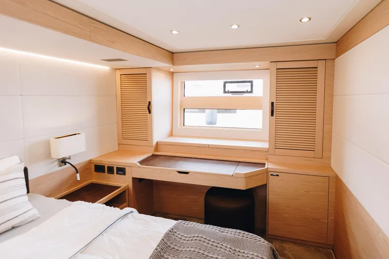 Slide: The Image of Luxurious cabin interior of 2024 Beneteau Grand Trawler 62 with modern wood finish. - 38