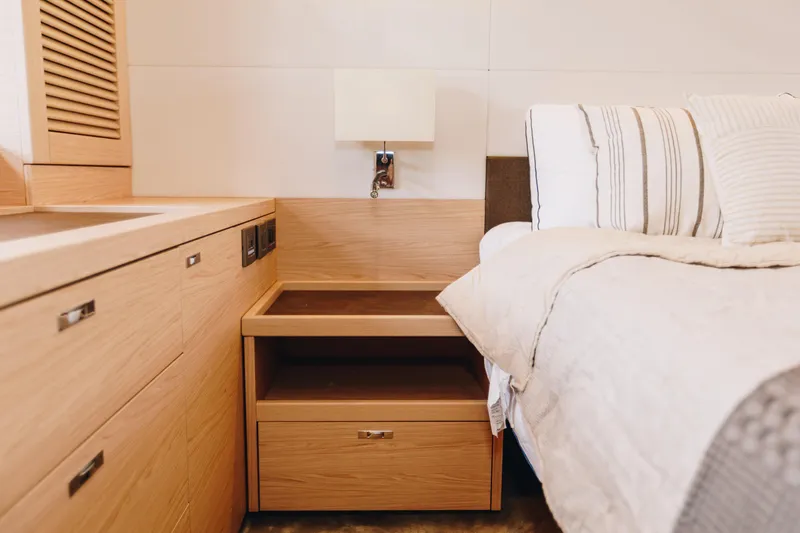 Slide: The Image of Luxurious bedroom interior of 2024 Beneteau Grand Trawler 62 with wooden cabinetry and cozy bedding. - 39