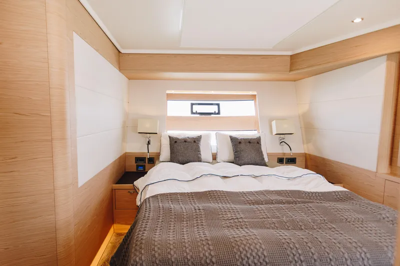 Slide: The Image of Luxurious bedroom interior of 2024 Beneteau Grand Trawler 62 yacht, featuring elegant wood finishes. - 43