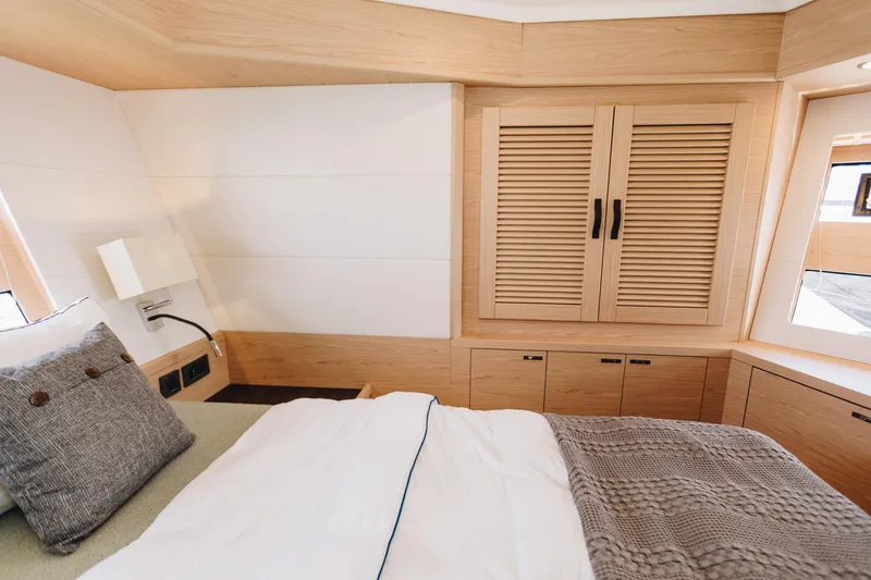Slide: The Image of Luxurious bedroom interior of 2024 Beneteau Grand Trawler 62 with wooden cabinetry and cozy bedding. - 45