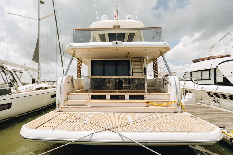 Slide: The Image of 2024 Beneteau Grand Trawler 62 yacht docked, showcasing spacious rear deck and modern design. - 5