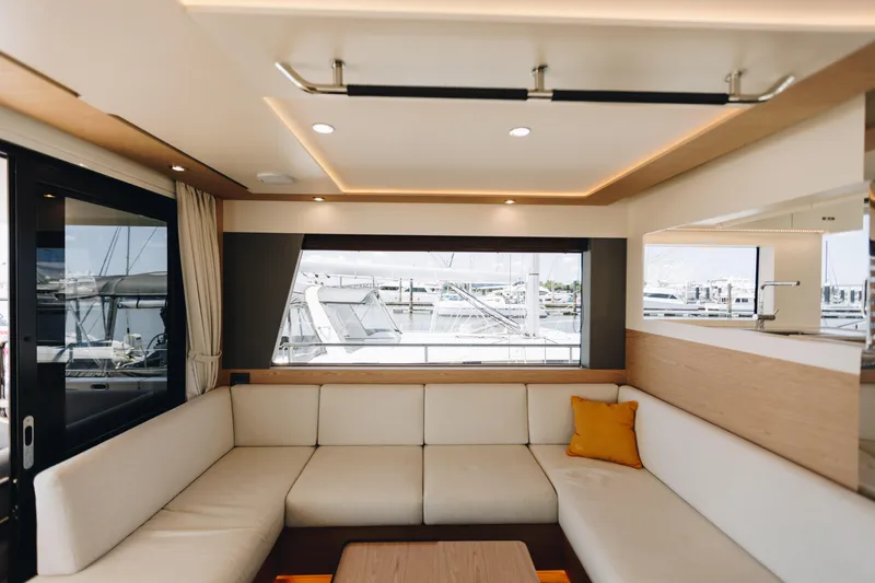 Slide: The Image of Luxurious interior of 2024 Beneteau Grand Trawler 62 with elegant seating and marina view. - 9