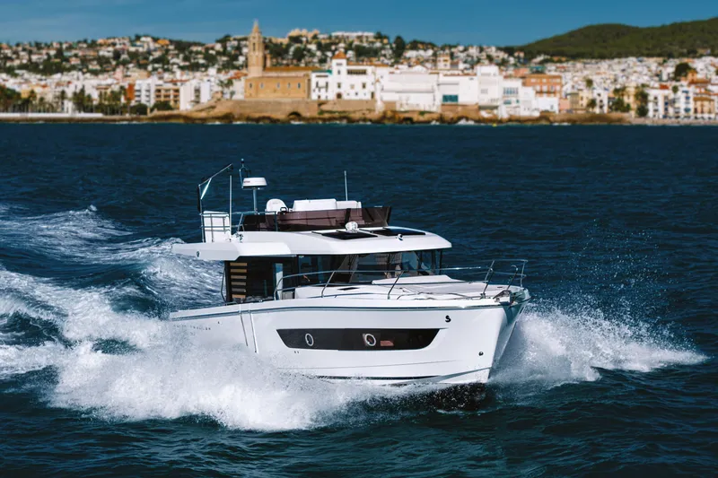 Slide: The Image of 2026 Beneteau Swift Trawler 37 Fly cruising near coastal cityscape. - 17
