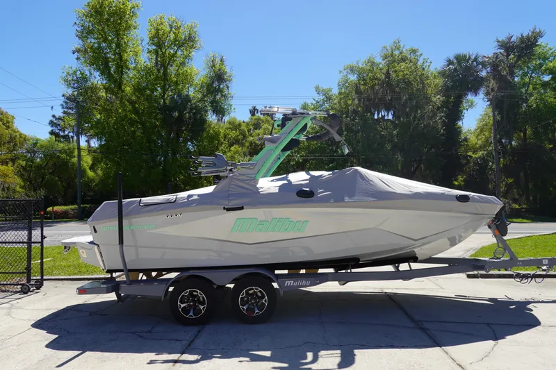 Slide: The Image of 2026 Malibu Wakesetter 22 LSV boat on trailer, covered, in sunny outdoor setting. - 45