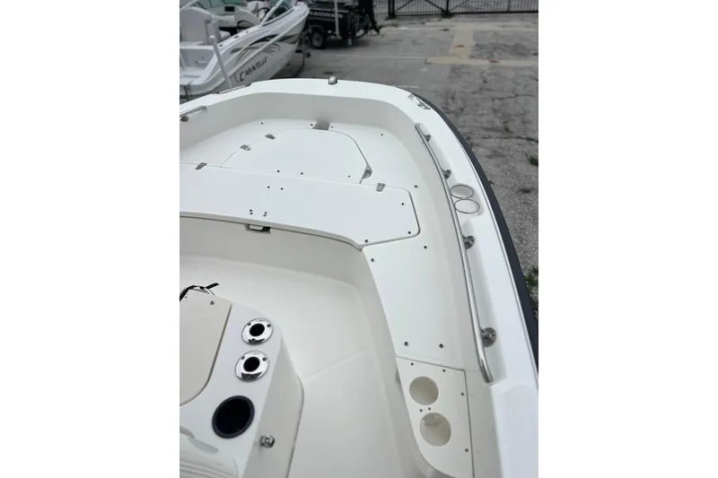 Slide: The Image of 2018 Boston Whaler 210 Dauntless boat interior, featuring sleek white deck and storage compartments. - 15