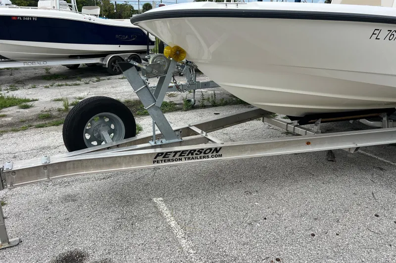Slide: The Image of 2018 Boston Whaler 210 Dauntless on Peterson trailer in parking lot. - 2