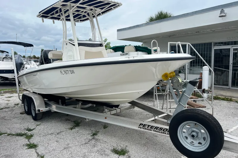 Slide: The Image of 2018 Boston Whaler 210 Dauntless boat on trailer, parked outside dealership. - 3