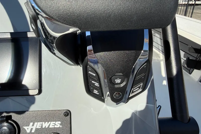 Slide: The Image of 2026 Hewes Redfisher 21 boat dashboard with controls and start/stop button. - 13