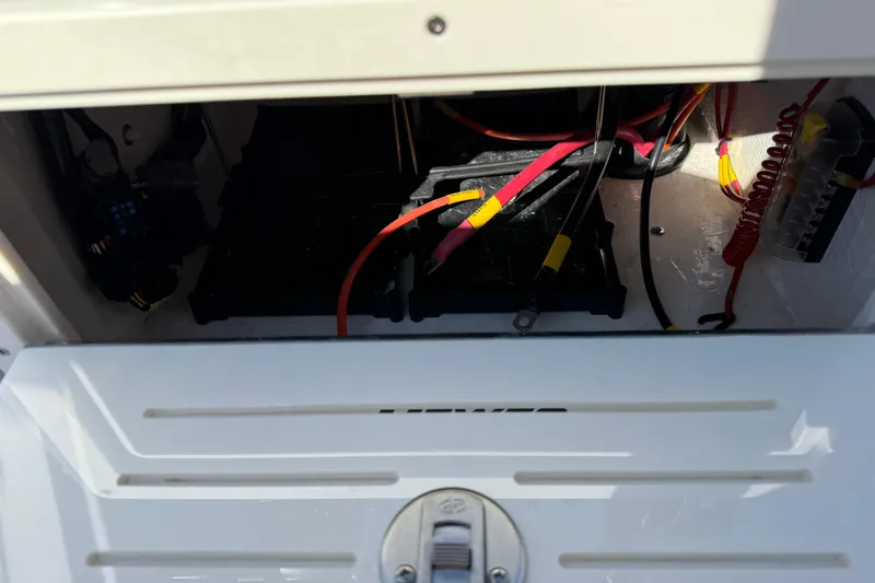 Slide: The Image of 2026 Hewes Redfisher 21 boat wiring compartment with visible cables and connections. - 17