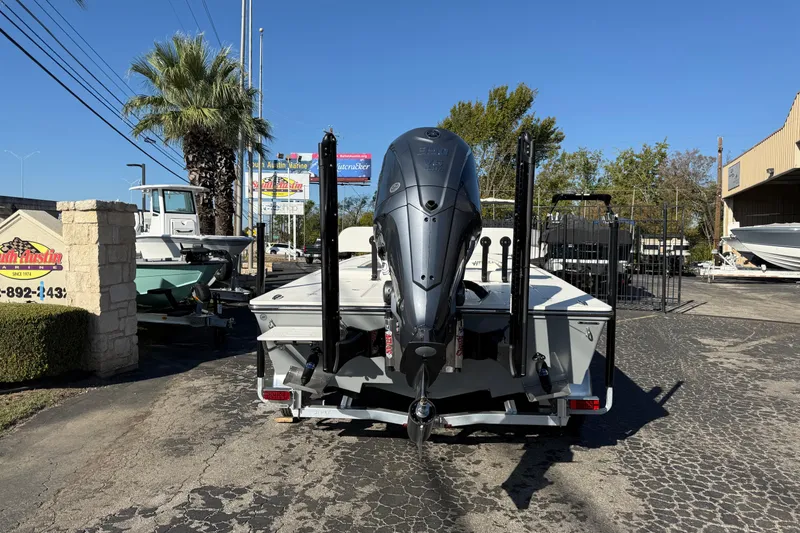 Slide: The Image of 2026 Hewes Redfisher 21 boat with outboard motor in a marina setting. - 2