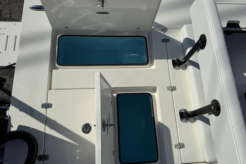 Slide: The Image of 2026 Hewes Redfisher 21 boat storage compartments with open lids and seating. - 29