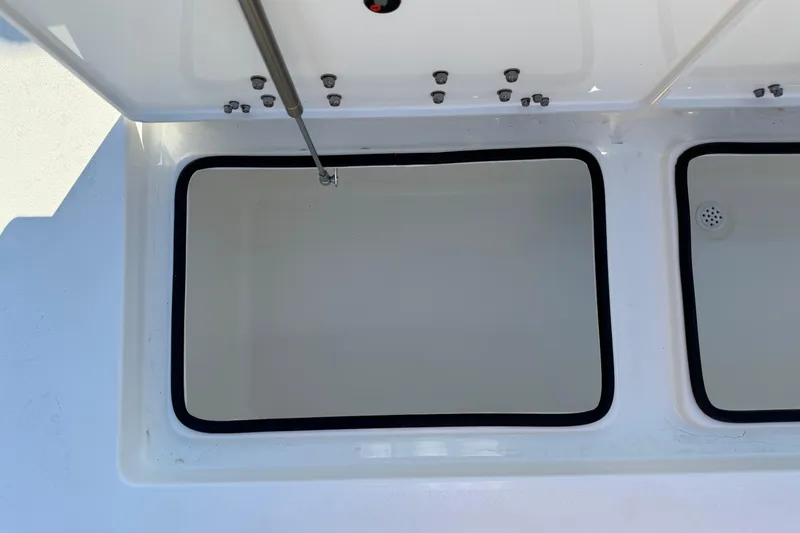 Slide: The Image of 2026 Hewes Redfisher 21 boat storage compartments with open lids and black seals. - 32