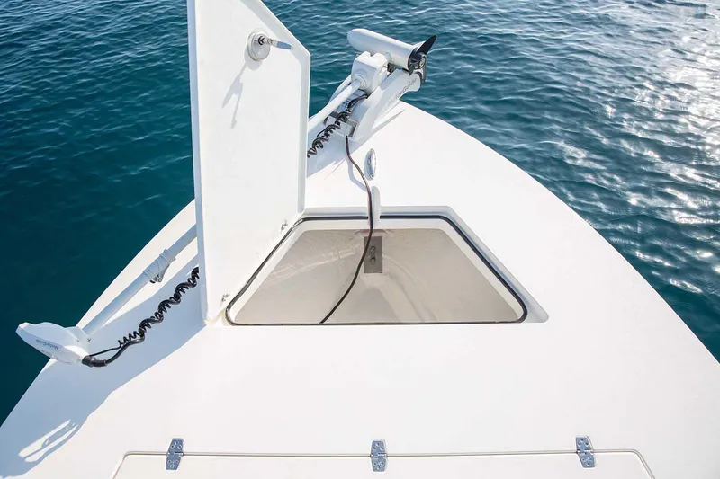 Slide: The Image of Manufacturer Provided Image: 2026 Hewes Redfisher 21 boat bow with open hatch, calm blue water background. - 49
