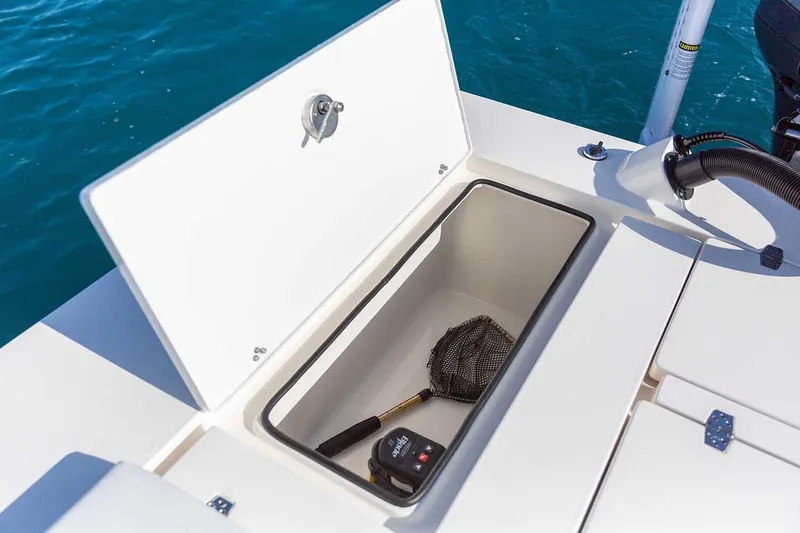Slide: The Image of Manufacturer Provided Image: 2026 Hewes Redfisher 21 boat storage compartment with fishing net and equipment. - 56