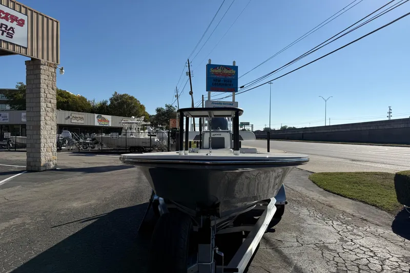 Slide: The Image of 2026 Hewes Redfisher 21 boat on trailer outside dealership, sunny day. - 8