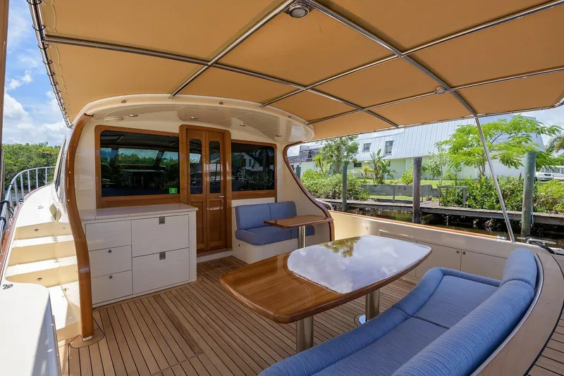 Slide: The Image of 2018 Palm Beach Motor Yachts PB55, elegant interior with wooden table, scenic waterfront view. - 11