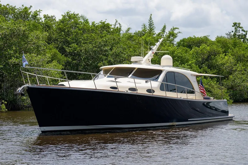 Slide: The Image of 2018 Palm Beach Motor Yachts PB55 cruising on calm waters under a clear blue sky. - 6