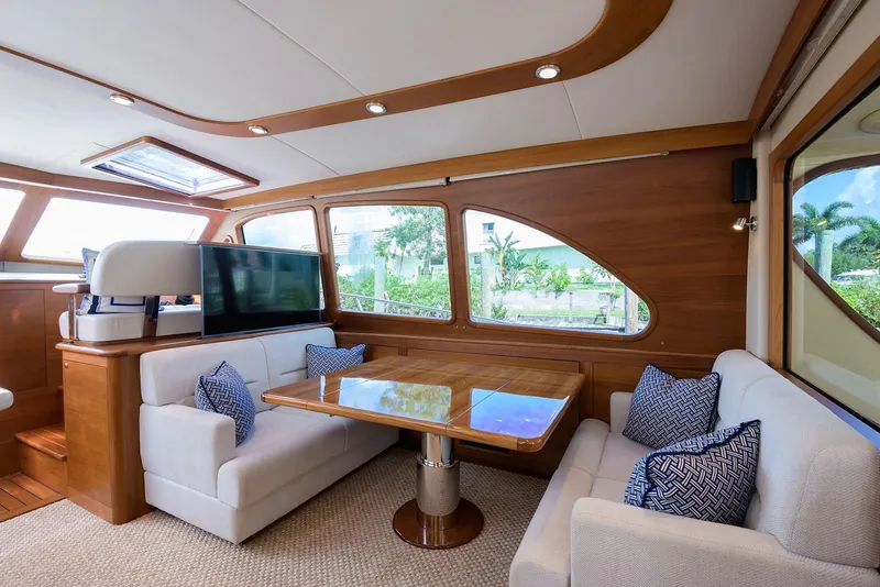 Slide: The Image of 2018 Palm Beach Motor Yachts PB55 helm with navigation display and scenic waterway view. - 2