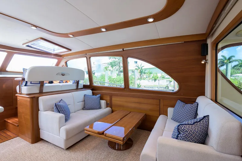 Slide: The Image of 2018 Palm Beach Motor Yachts PB55 helm with navigation display, steering wheel, and scenic waterway view. - 25