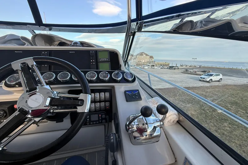 Slide: The Image of 2006 Formula 40 Performance Cruiser cockpit with steering wheel and control panel, overlooking marina. - 26