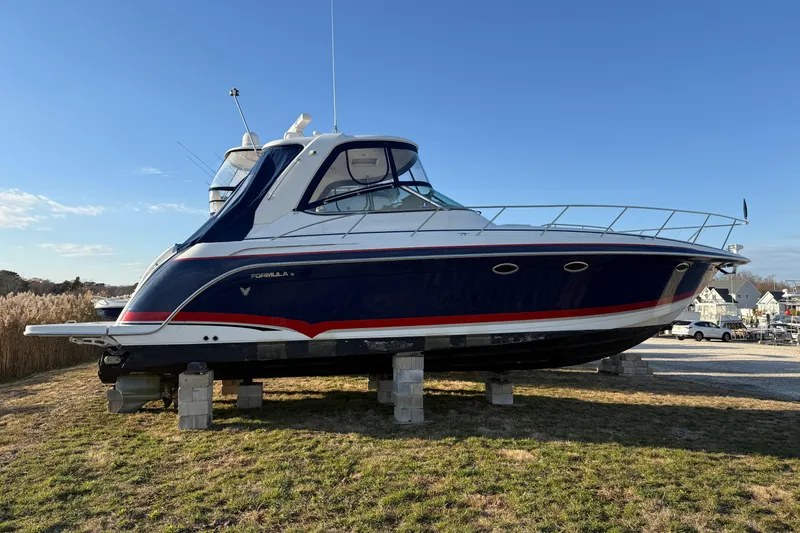 Slide: The Image of 2006 Formula 40 Performance Cruiser on blocks, blue and white design, outdoor setting. - 41