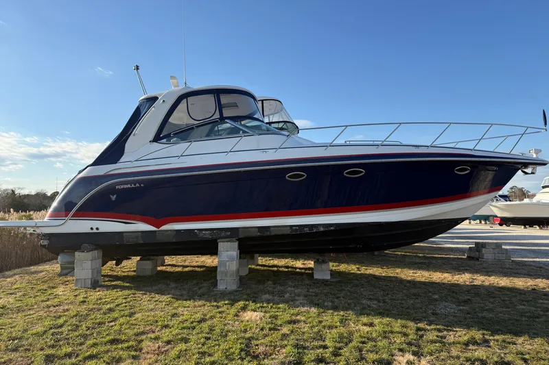 Slide: The Image of 2006 Formula 40 Performance Cruiser on blocks, blue and white design, sunny day. - 42