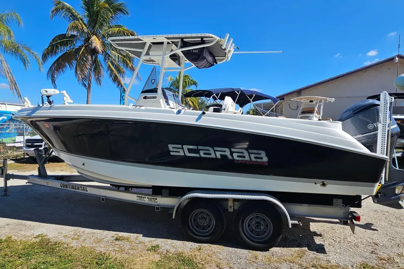 Slide: The Image of 2015 Wellcraft 252 Fisherman boat on trailer, parked outdoors under clear blue sky. - 5