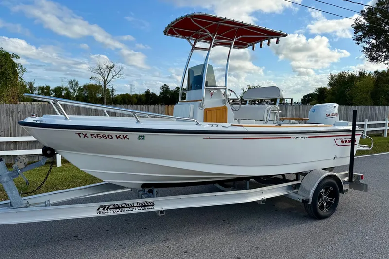 The Image of 1997 Boston Whaler Outrage 17 boat on trailer, parked outdoors under a blue sky. - 0