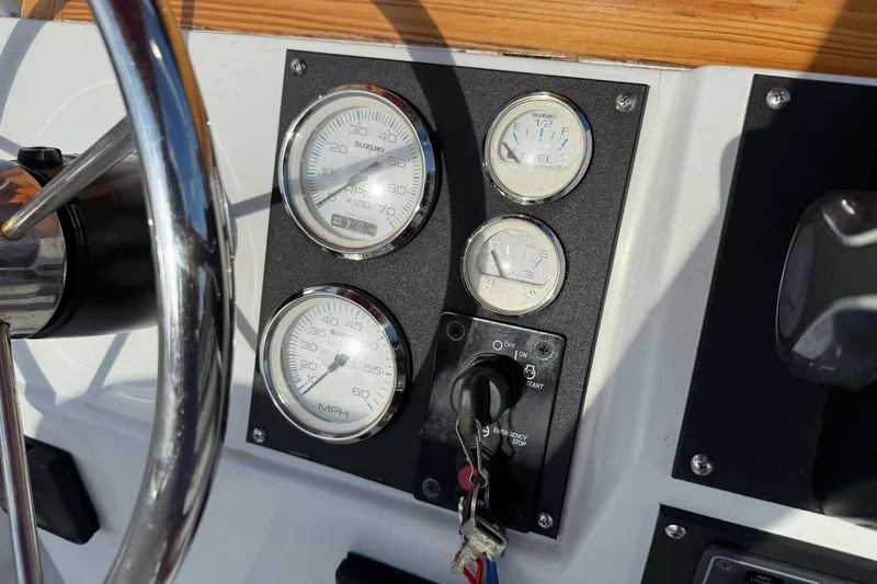 Slide: The Image of 1997 Boston Whaler 17 Outrage II dashboard with gauges and steering wheel. - 16