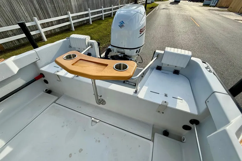 Slide: The Image of 1997 Boston Whaler 17 Outrage II boat interior with Suzuki outboard motor and wooden table. - 6