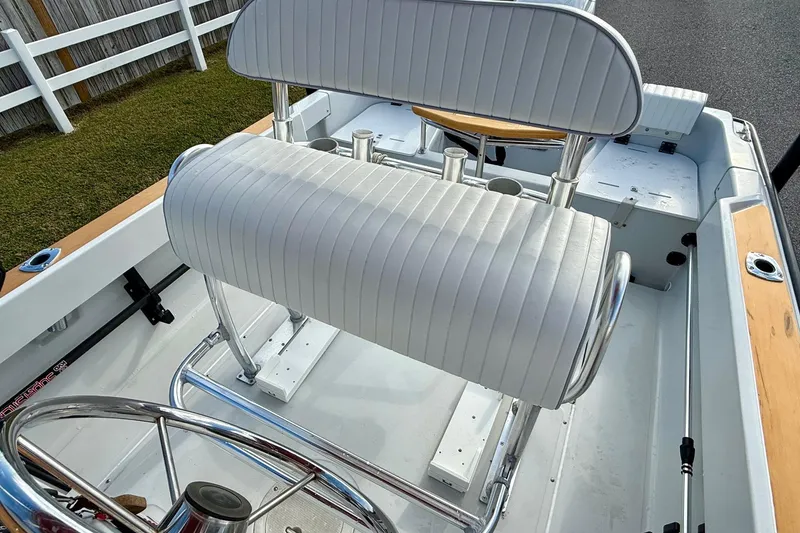 Slide: The Image of 1997 Boston Whaler 17 Outrage II boat interior with white cushioned seating and steering wheel. - 8
