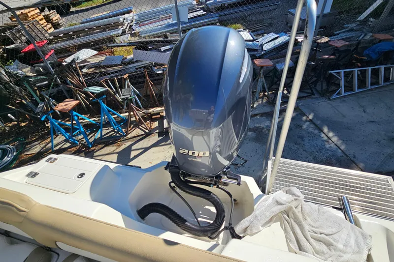 Slide: The Image of 2017 Key West 239 FS boat with Yamaha 200 engine, docked near metal structures. - 18