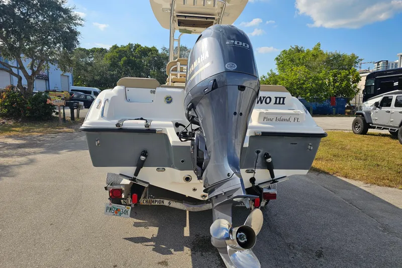 Slide: The Image of 2017 Key West 239 FS boat with Yamaha 200 engine, parked outdoors. - 4