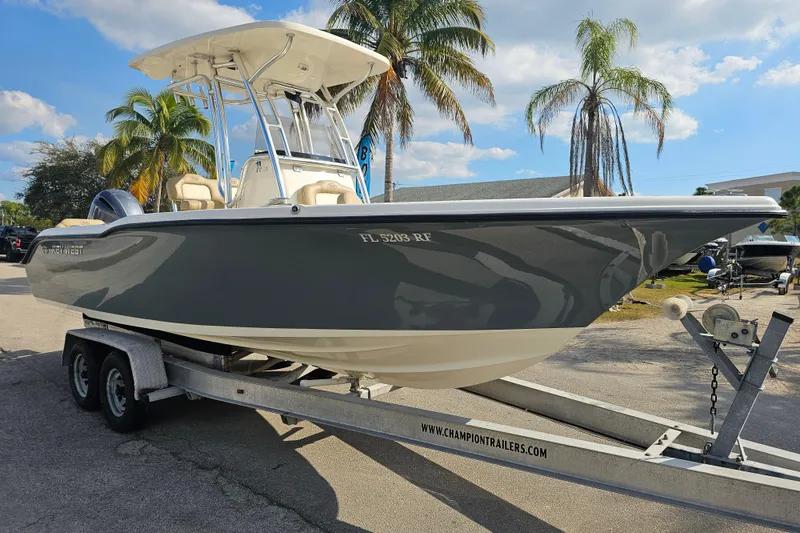 Slide: The Image of 2017 Key West 239 FS boat on trailer, parked near palm trees under a blue sky. - 6