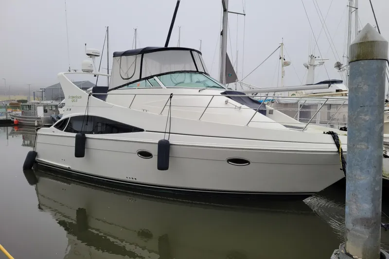 Slide: The Image of 2006 Carver 36 Mariner yacht docked at marina, featuring sleek design and spacious deck. - 1