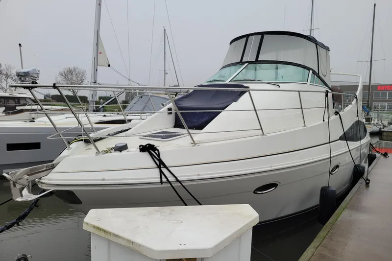 Slide: The Image of 2006 Carver 36 Mariner yacht docked at marina, overcast sky, side view. - 2