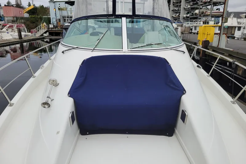Slide: The Image of 2006 Carver 36 Mariner yacht docked, featuring a blue covered seating area on deck. - 72