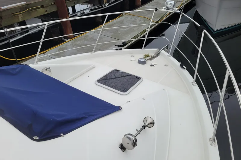 Slide: The Image of 2006 Carver 36 Mariner yacht bow with railing and blue cover at dock. - 70