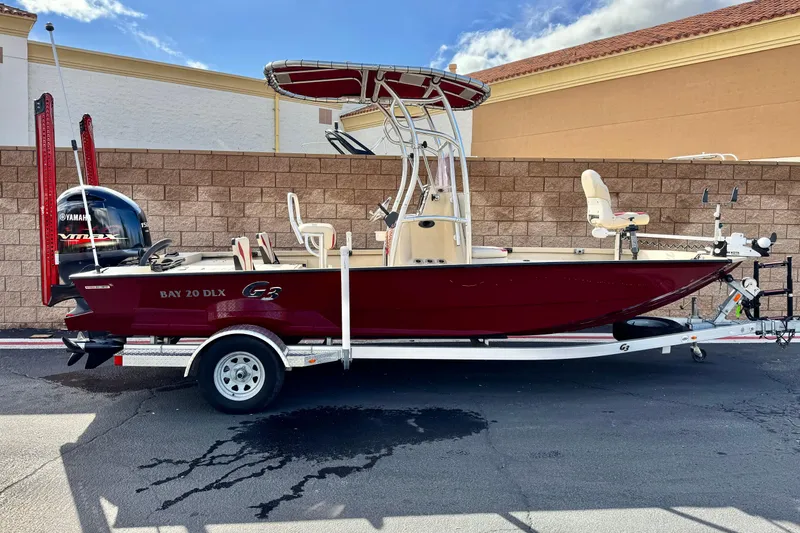 The Image of 2021 G3 Bay 20 DLX boat on trailer, red hull, Yamaha engine, outdoor setting. - 0