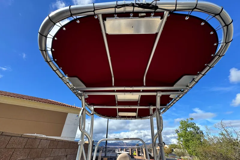 Slide: The Image of 2021 G3 Bay 20 DLX boat with red canopy under a clear blue sky. - 11