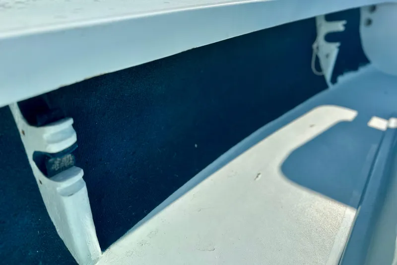 Slide: The Image of Interior view of a 1986 Dolphin 16 SUPER SKIFF boat, showcasing seating and storage area. - 12