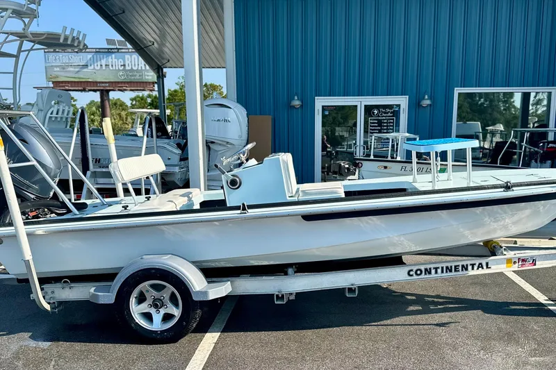 Slide: The Image of 1986 Dolphin 16 SUPER SKIFF boat on trailer outside a blue building. - 5