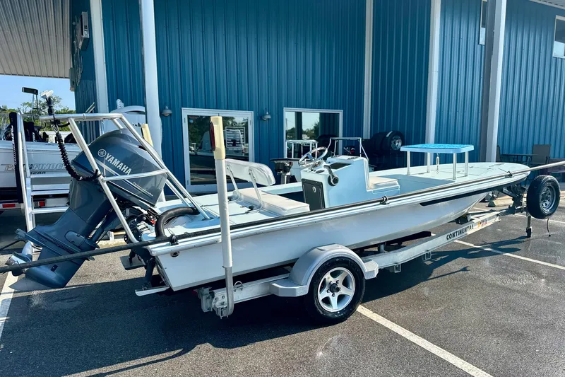 Slide: The Image of 1986 Dolphin 16 SUPER SKIFF boat on trailer with Yamaha outboard motor, parked outside blue building. - 6