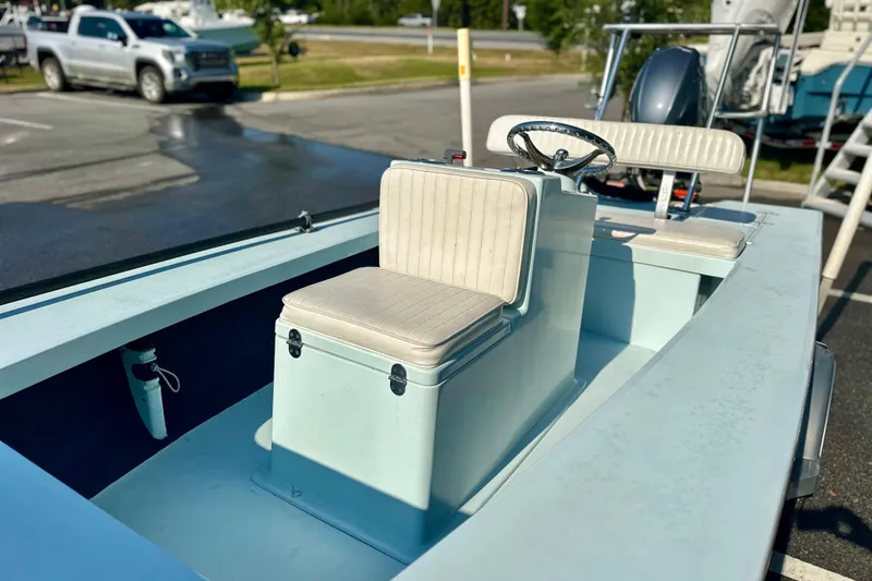 Slide: The Image of 1986 Dolphin 16 SUPER SKIFF boat with dual seats and steering wheel in a parking lot. - 9