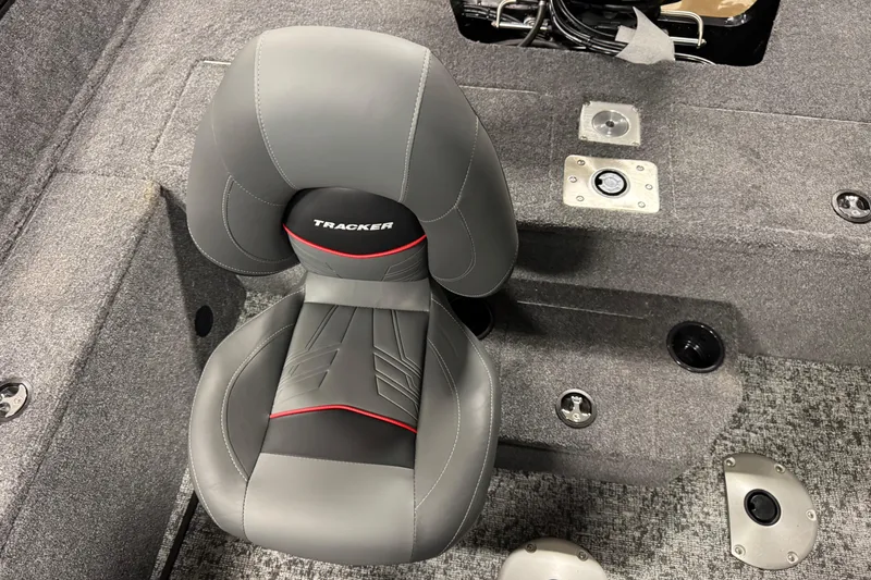 Slide: The Image of 2026 Tracker Pro Guide V-175 WT boat seat, gray with red accents, on carpeted deck. - 11