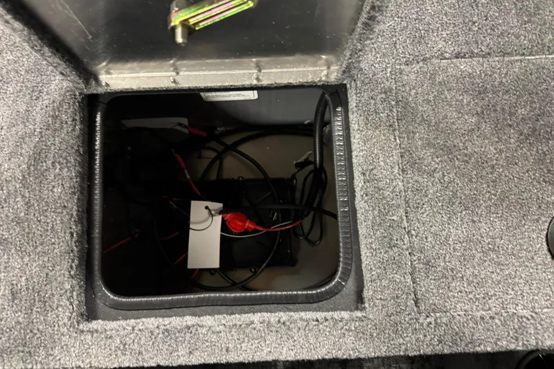 Slide: The Image of 2026 Tracker Pro Guide V-175 WT battery compartment with wiring and carpeted interior. - 13
