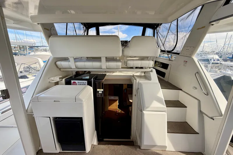 Slide: The Image of 1997 Carver 355 Aft Cabin Motor Yacht interior with seating and stairs, docked at marina. - 10